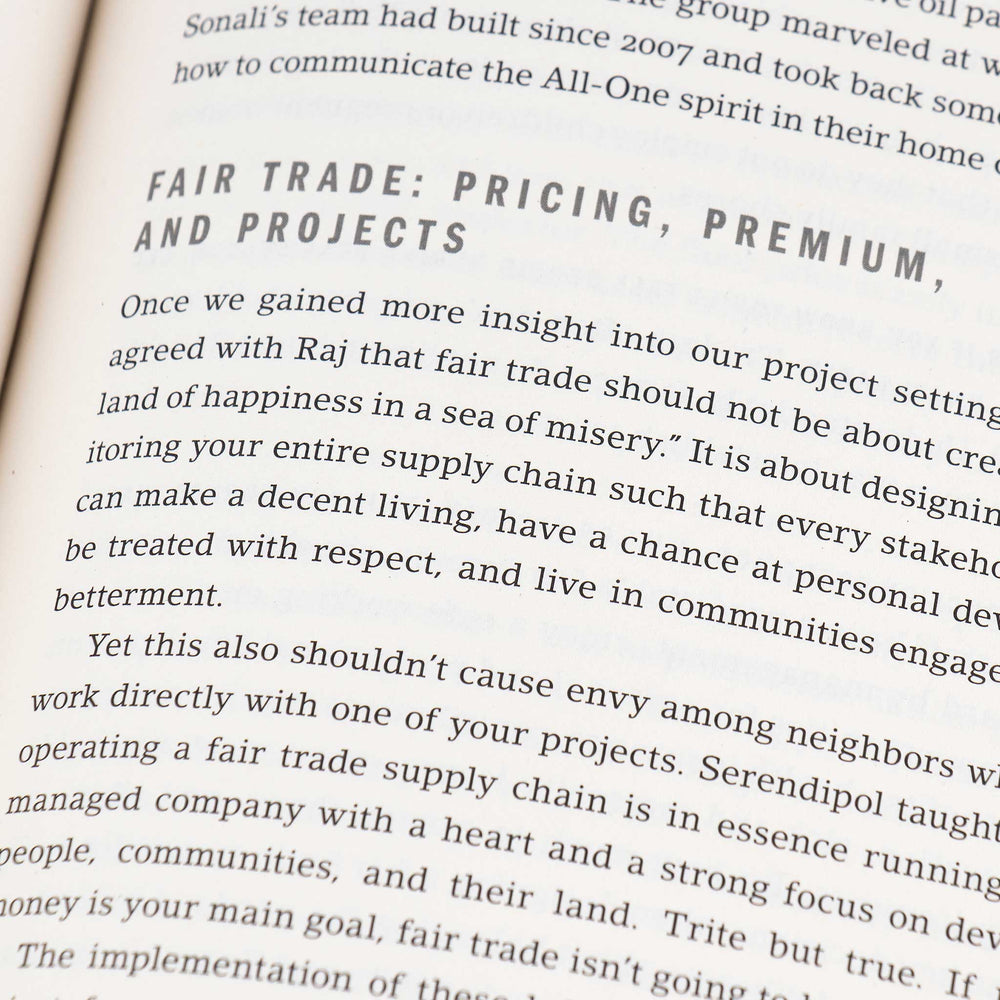 A close up of a book page, focusing on a chapter titled Fair Trade Pricing, Premium, and Projects. The text discusses fair trade concepts, emphasizing equitable supply chain practices for community betterment