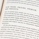 A close up of a book page, focusing on a chapter titled Fair Trade Pricing, Premium, and Projects. The text discusses fair trade concepts, emphasizing equitable supply chain practices for community betterment