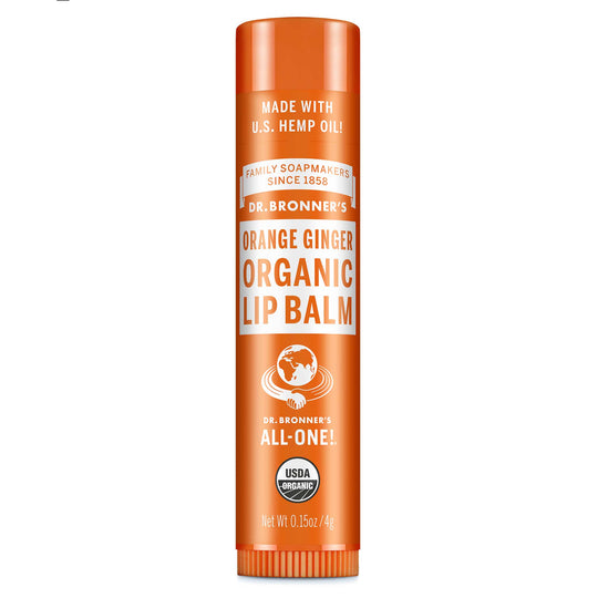 Dr. Bronners Orange Ginger Organic Lip Balm, with U.S. hemp oil, stands upright against a white background. Text includes Family Soapmakers Since 1858, All One, USDA Organic, Net Wt 0.15oz4g [.15 oz]