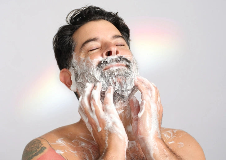 A man, eyes closed, lathers his face and body with foamy soap in a serene setting, highlighting relaxation and self care, emphasizing the benefits of organic, natural products [7 oz]