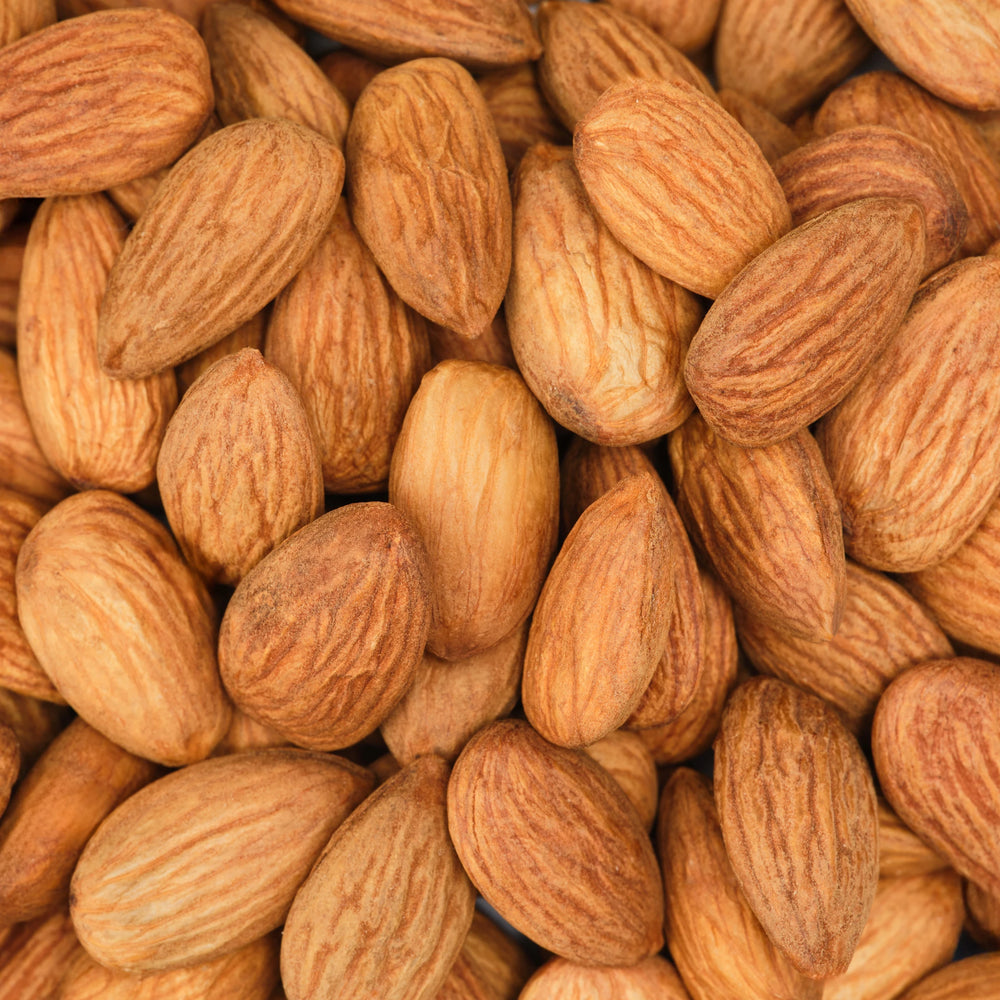 Close up of numerous whole almonds, characterized by their textured, brown shells. They are tightly clustered together, creating a natural, organic pattern. Perfect imagery for promoting natural products like organic soap or eco friendly skincare items [5 oz]