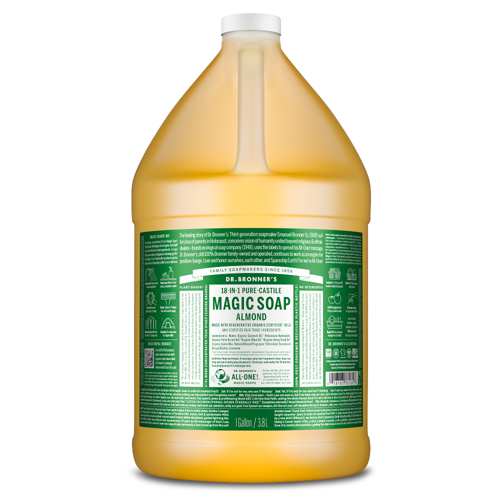 A large, transparent jug filled with a golden liquid features a green label. The text reads Dr. Bronners Magic Soap, 18 in 1 Pure Castile, Almond, 1 Gallon 3.8L. Eco friendly product details are printed below in white [1 Gallon]