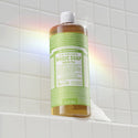 Bottle of Dr. Bronner's Magic Soap Green Tea on a tiled bathroom wall. [32 oz]