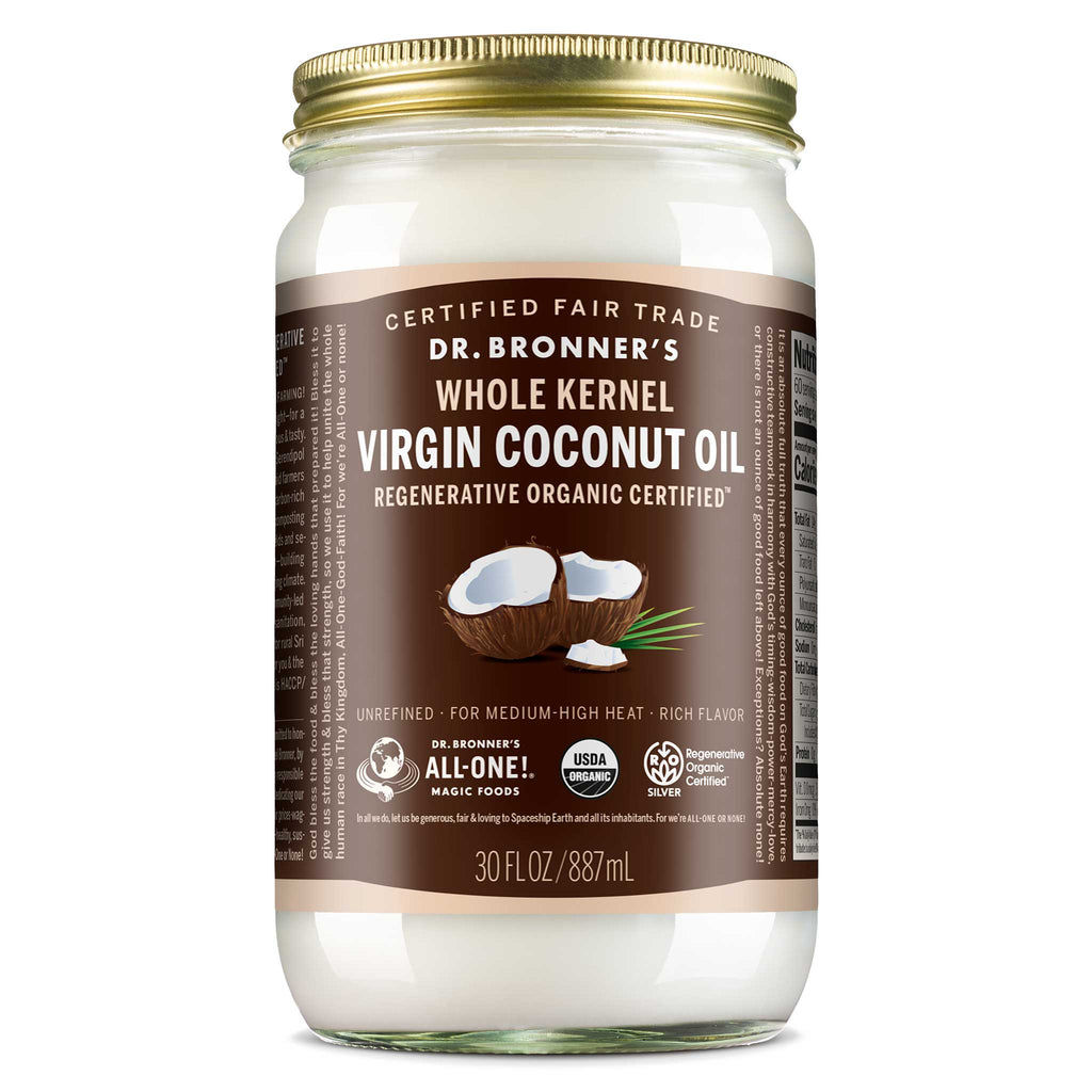 A glass jar with a gold lid contains Dr. Bronners Whole Kernel Virgin Coconut Oil. Its labeled Regenerative Organic Certified and 30 FL OZ 887 mL. The label highlights it as Certified Fair Trade and suitable for medium high heat cooking [30 oz]