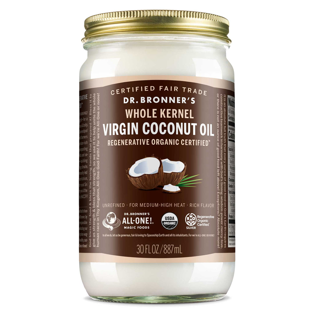 A glass jar with a gold lid contains Dr. Bronners Whole Kernel Virgin Coconut Oil. Its labeled Regenerative Organic Certified and 30 FL OZ 887 mL. The label highlights it as Certified Fair Trade and suitable for medium high heat cooking [30 oz]