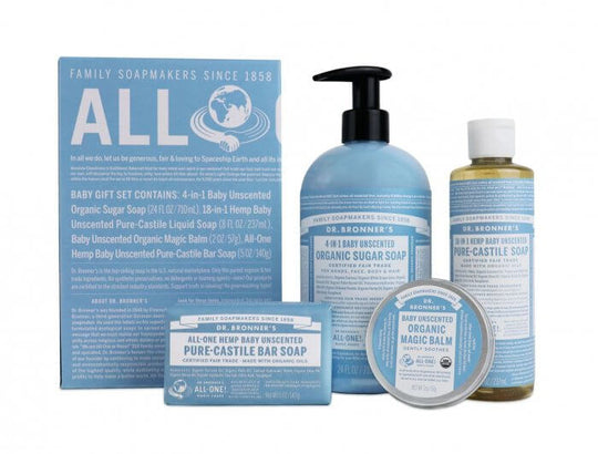 Dr. Bronners Baby Unscented collection includes a boxed bar soap, pump bottle, liquid soap, and small tin, ideal for sensitive skin. Labels highlight organic and fair trade ingredients amidst a white backdrop. Text on the box reads ALL ONE Dr. Bronners magic soaps are certified under the USDA National Organic Program. No detergents or foaming agents. Enjoy only 2 cosmetics, enough sleep Dr. Bronners magic soap to clean body mind soul spirit instantly uniting one All One